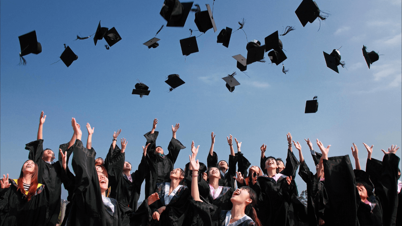 University students throwing their graduation caps in the air