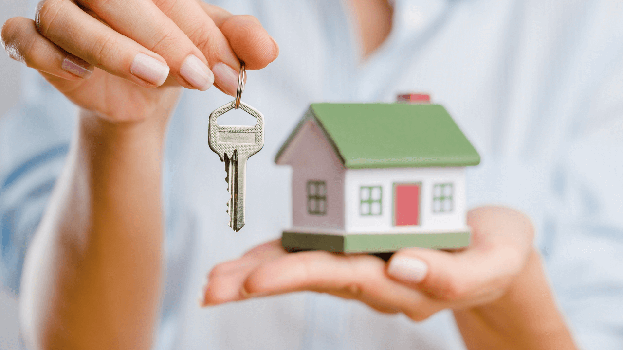 Woman holding a key and house in her hands