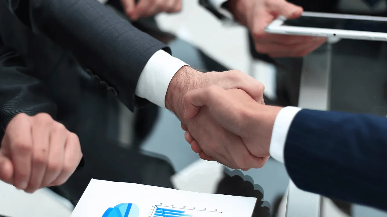 investors and employees shaking hands in an office
