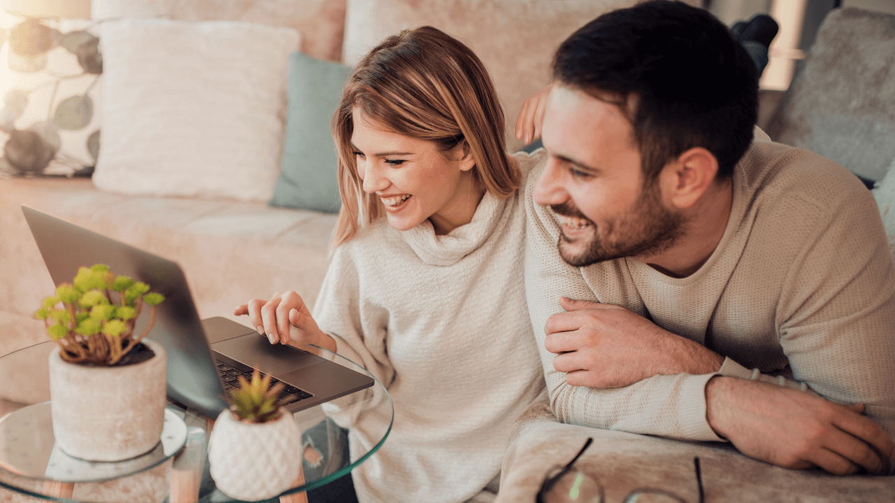 Two happy people excited at seeing their immigration approval on their laptop