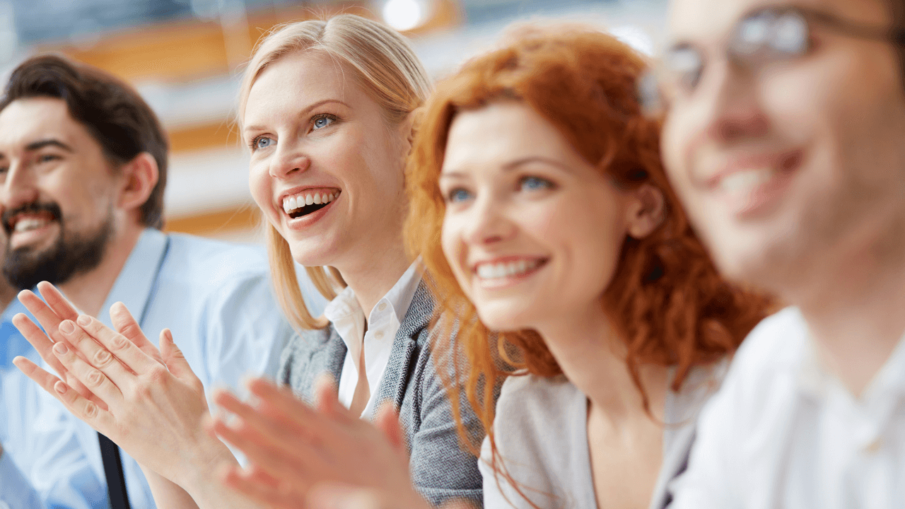 An office team clapping with excitement at another approval