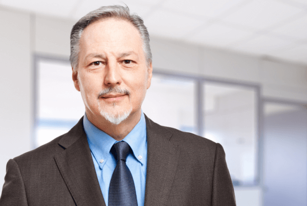 A business man in a suit and tie smiling in the office
