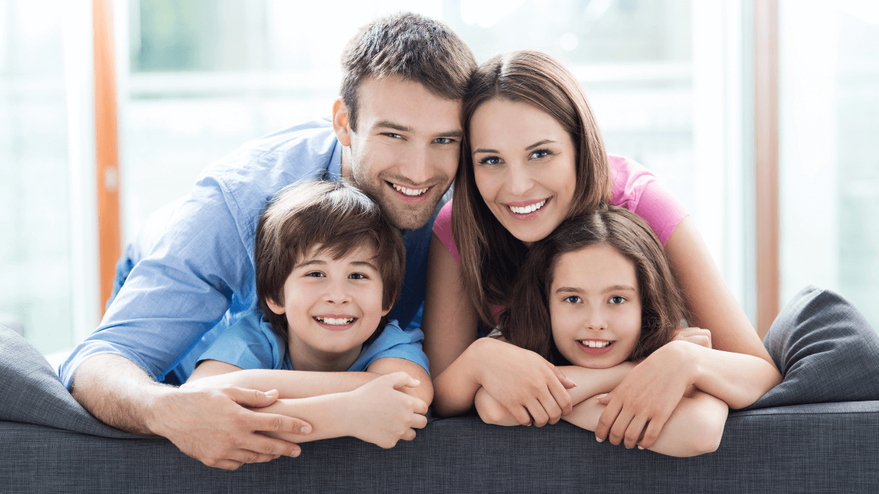 A family- mother, father, and two children smiling