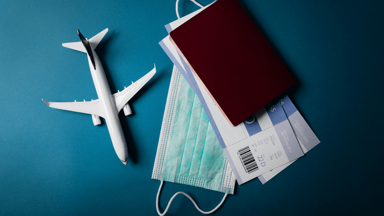 an airplane, passport, mask, and airline tickets