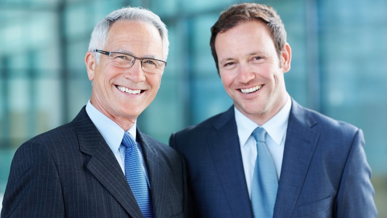 Two business partners dressed in suits smiling