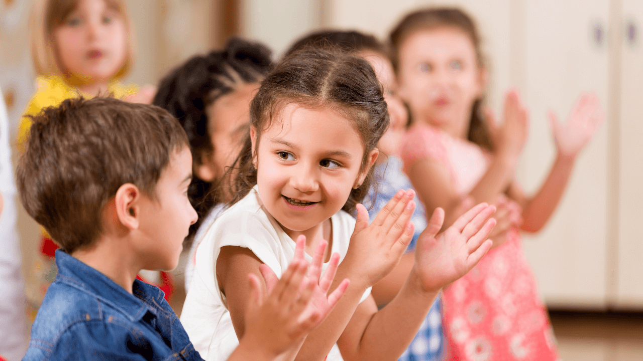 A bunch of children clapping together