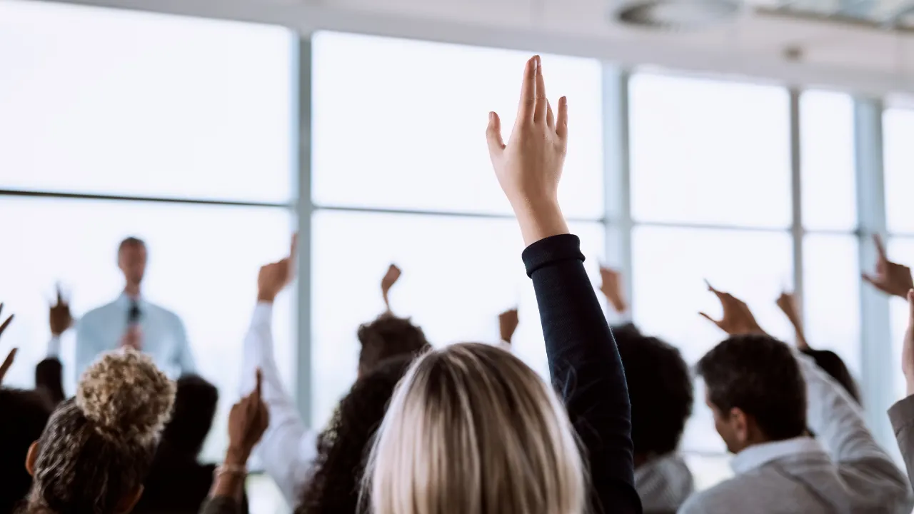 People raising their hands to ask a question