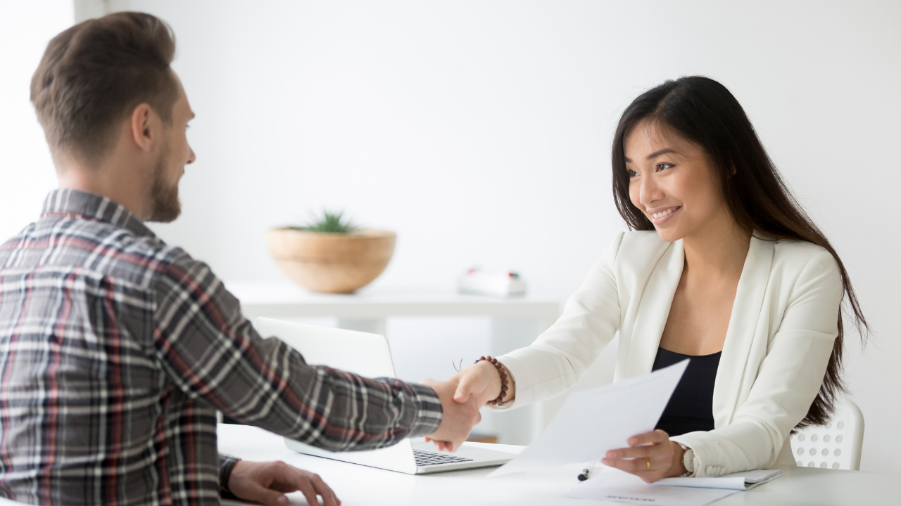 Two pwople shaking hands to solidify a A job offered after an interview