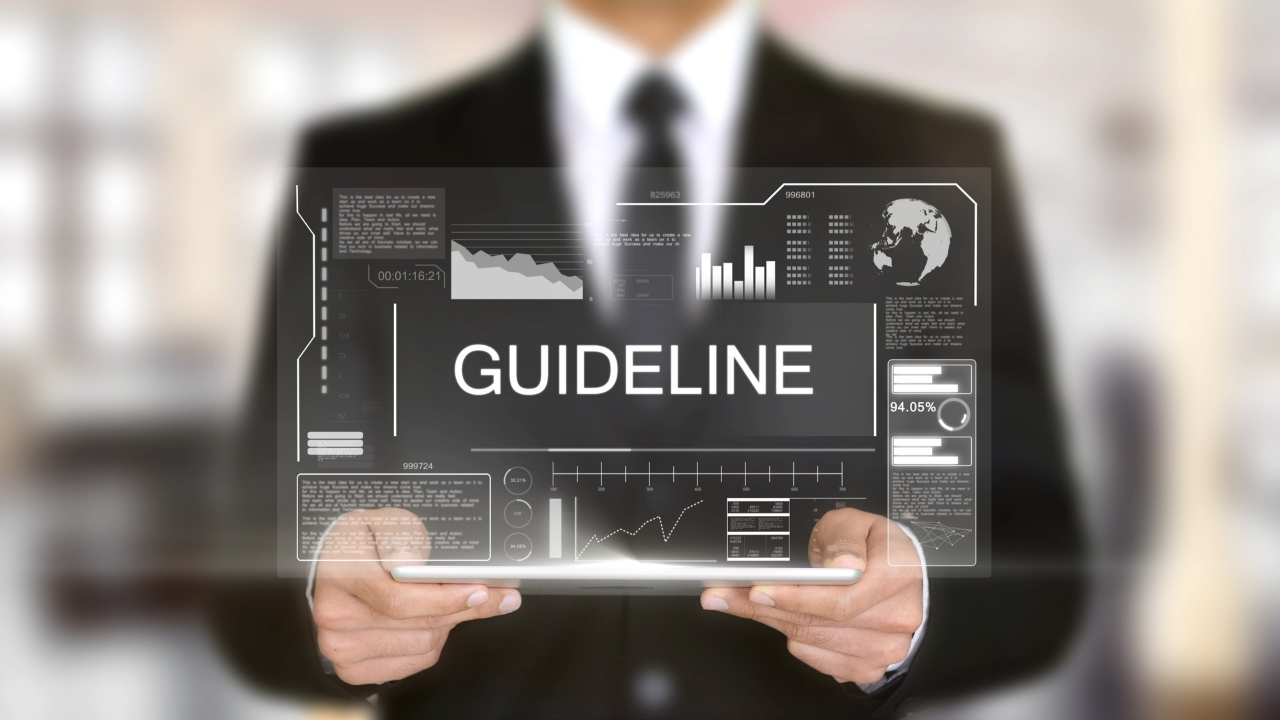 A man holding a tablet that projects the word "Guideline" in front of him