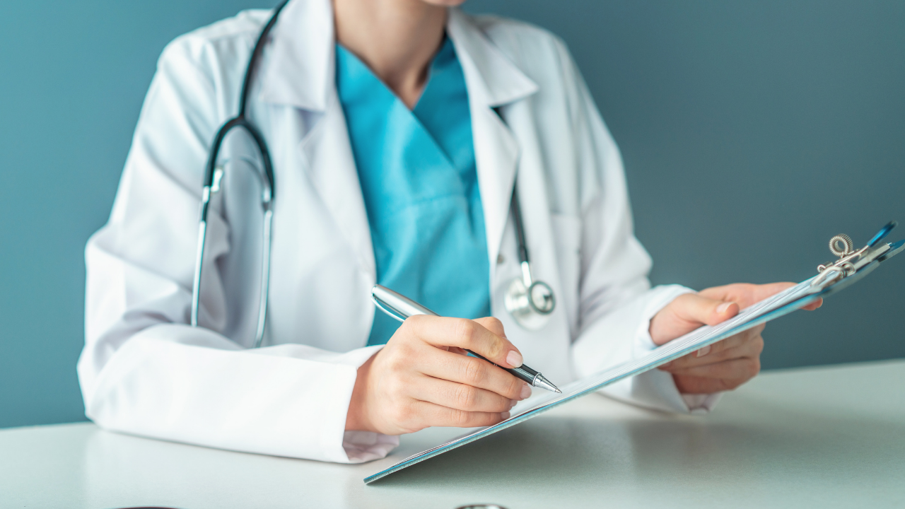 A doctor filling out a medical report on a clipboard