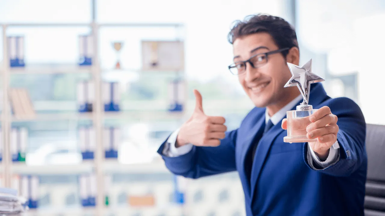A man holding an award for being extraordinary