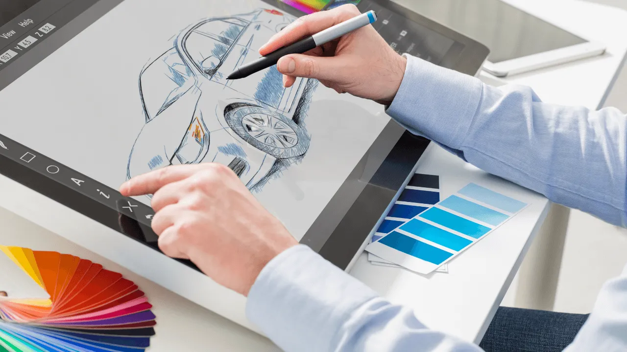 A graphic designer working on a car design on a tablet with color swatches next to them