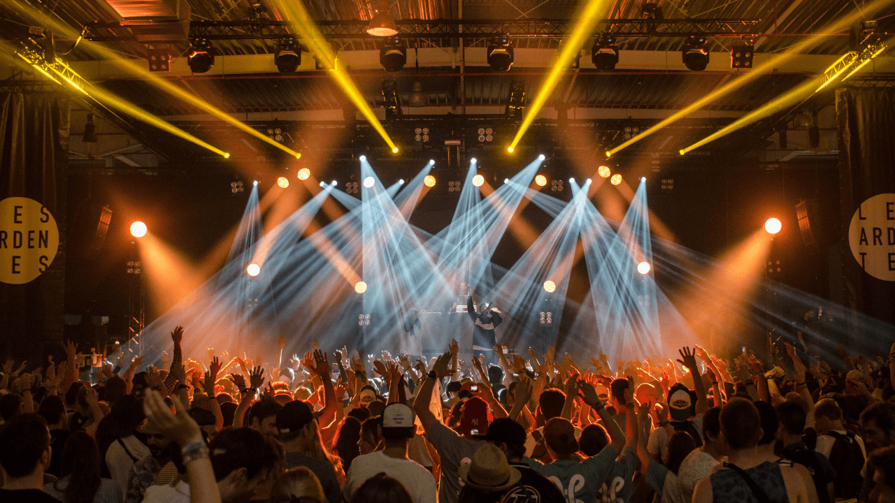 A concert venue with bright lights and a full crowd