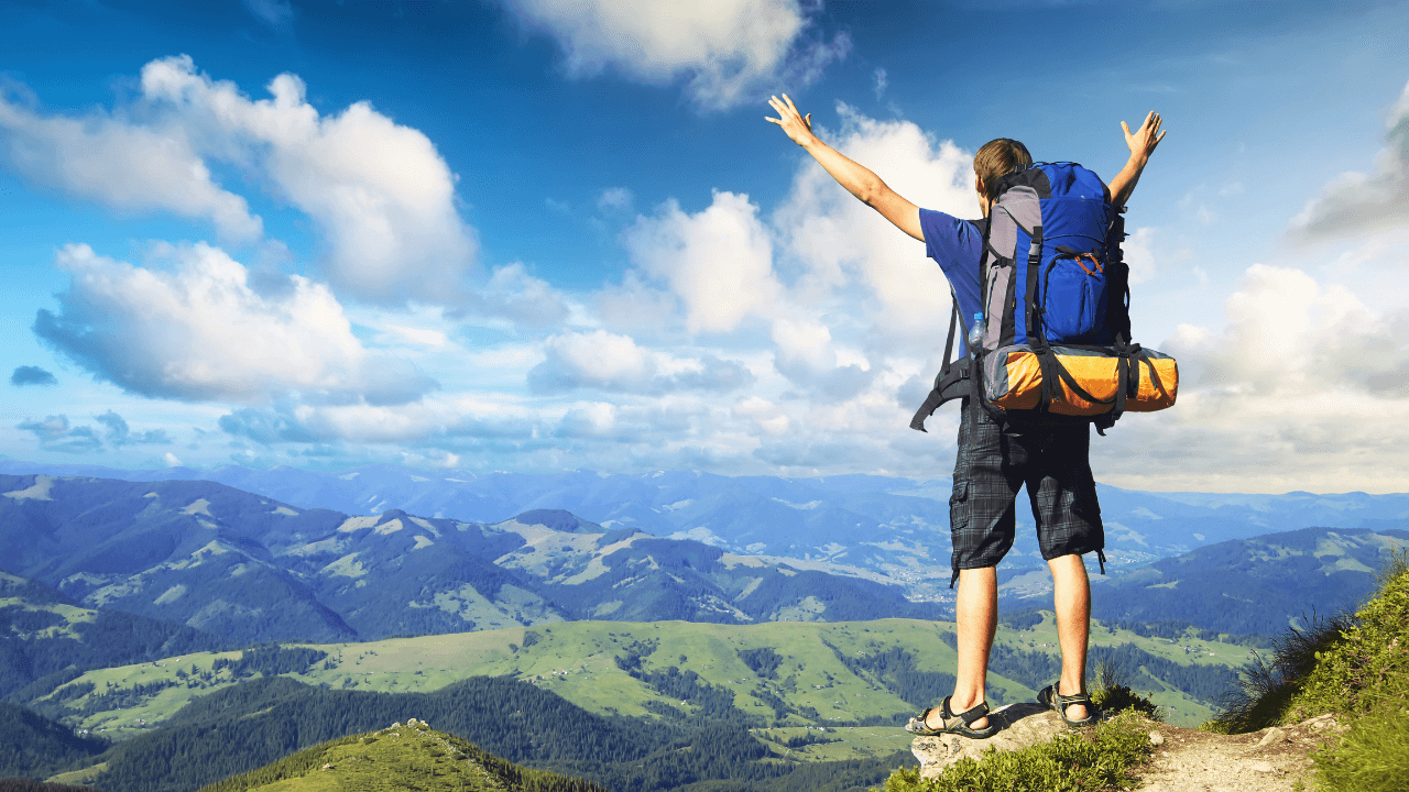 A man celebrating a successful hike