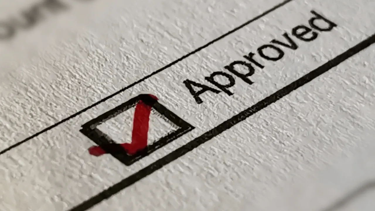 An "approved" box checked on a piece of paper