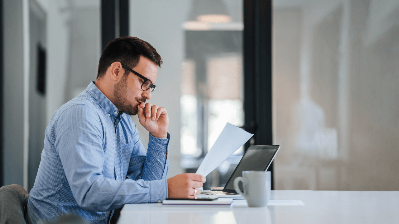 A business immigration analyst reviewing documents while sitting in the office