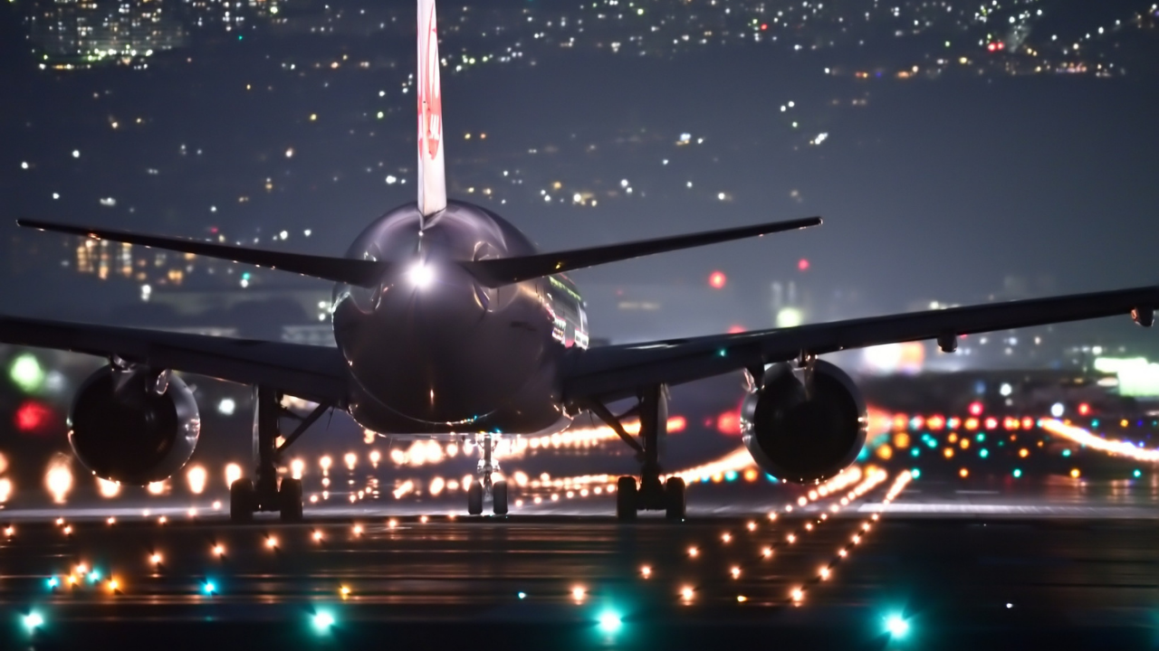 An airplane on the runway at an airport at night