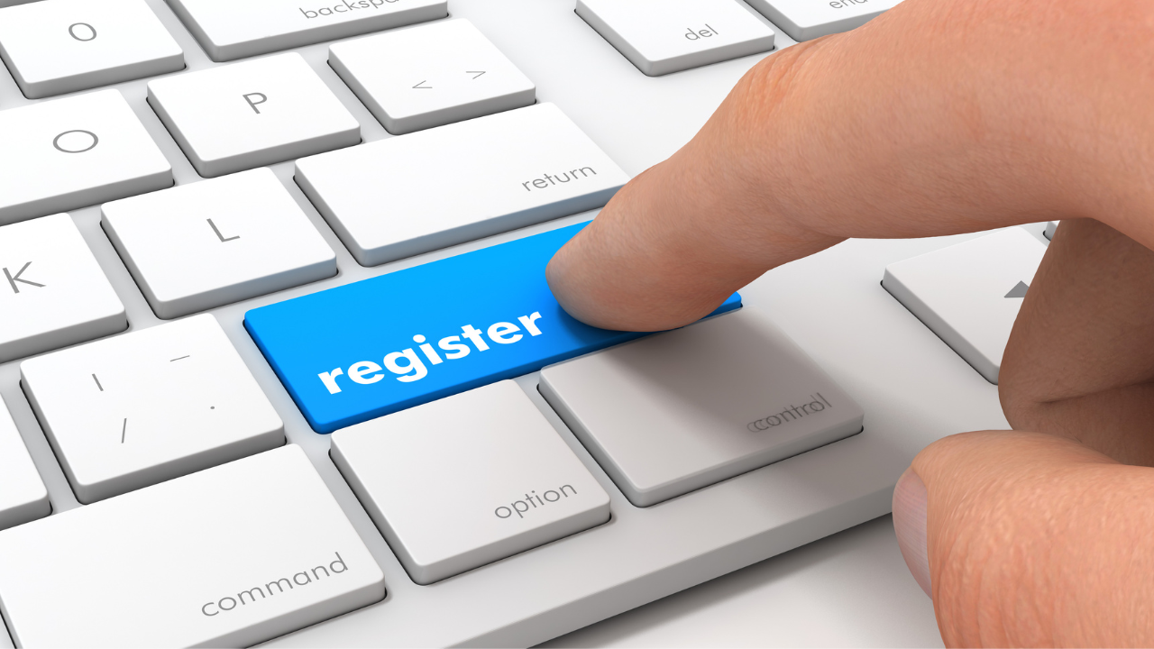 A man hitting the "register" key on a keyboard