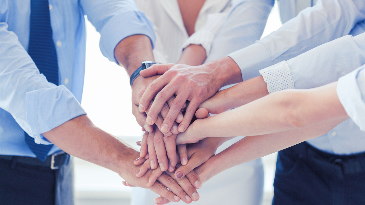 An office team stacking their hands in cooperation and teamwork