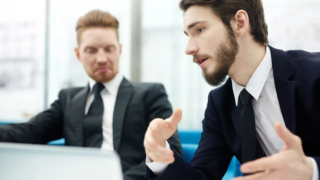 Two economist in business suits speaking with each other