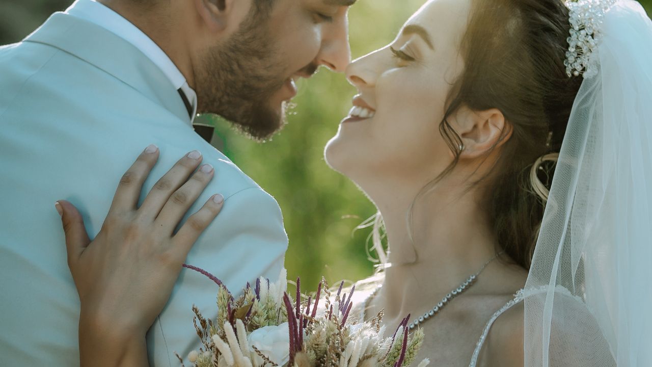 A Married couple smiling at each other in a wedding photo