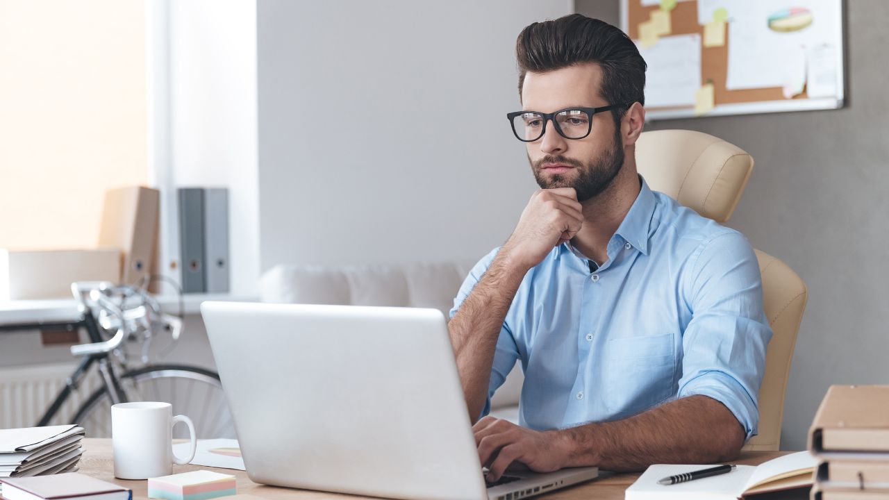 A man working on his laptop from his desk