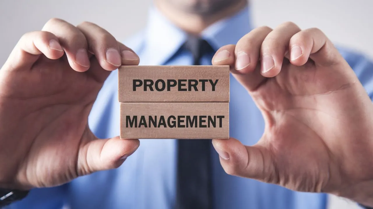A man in a suit holding blovks that say "property management"