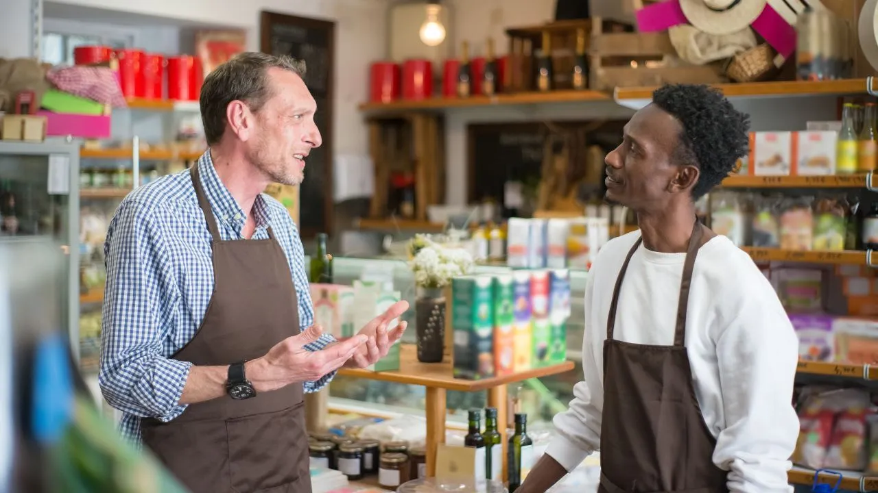 Two convenience store workers speaking to each other
