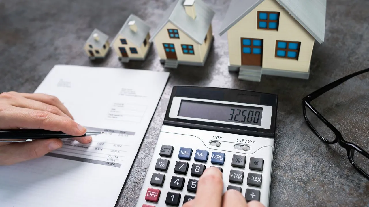 Houses, a calculator, and tax form on a desk