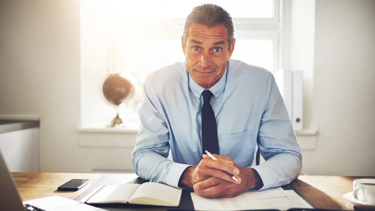 A happy executive sitting at his desk
