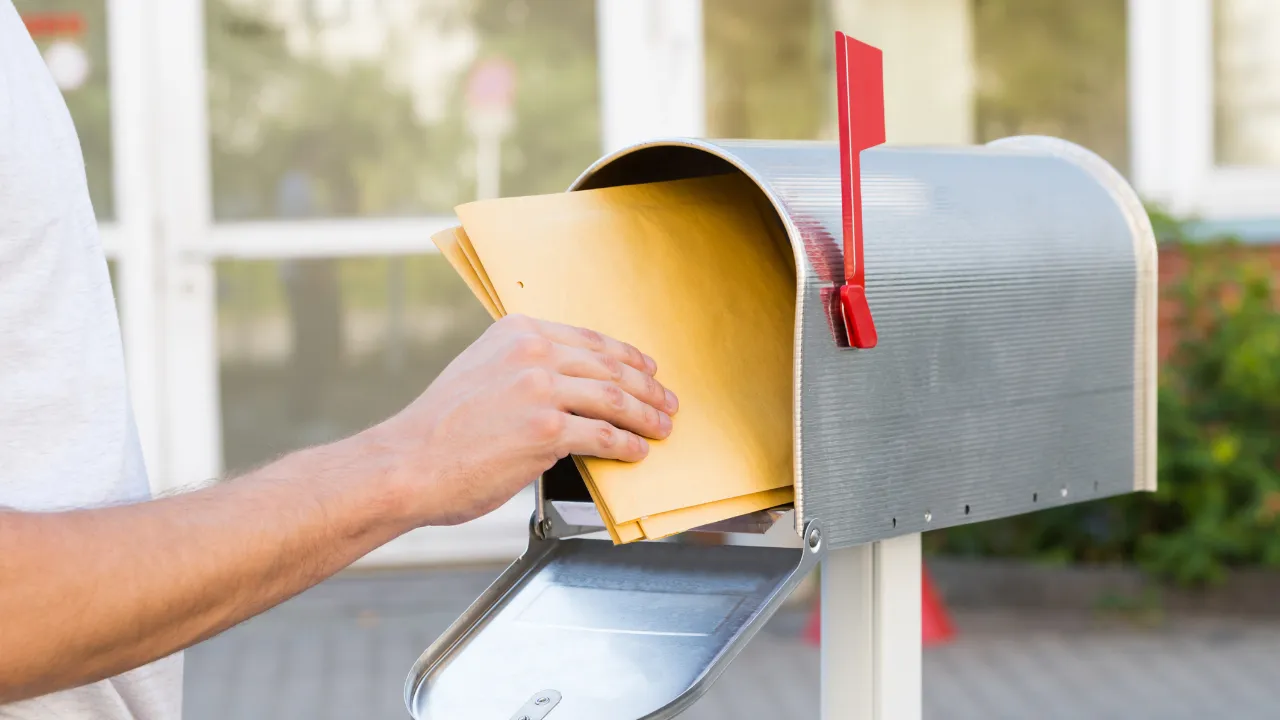 A man claiming his mail from his mailbox