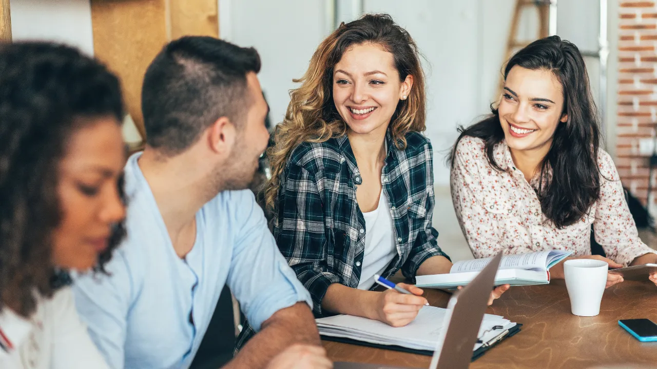 A group of university students sitting around a table in class