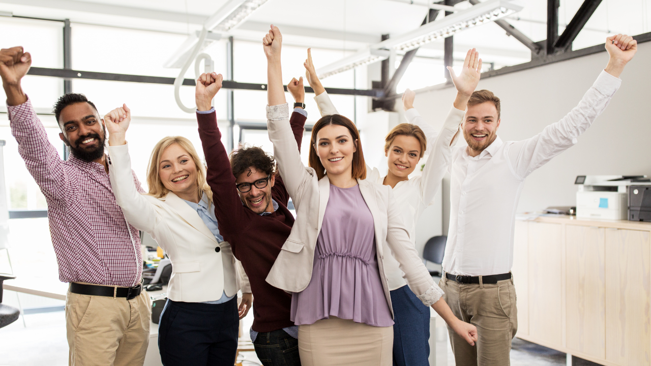 An office team celebrating an approval and win