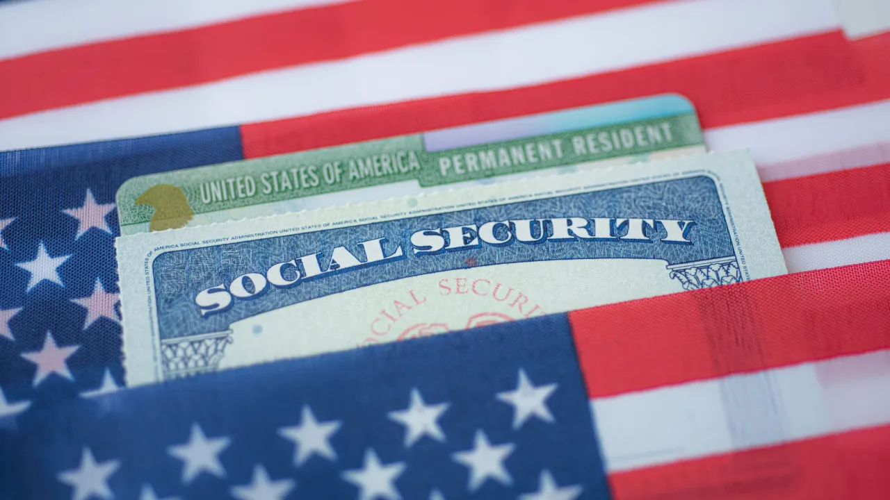 a green card, social security card and US flag