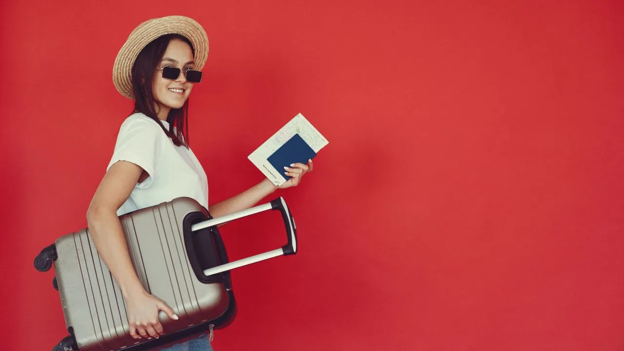 A woman getting ready to travel with her passport and suitcase