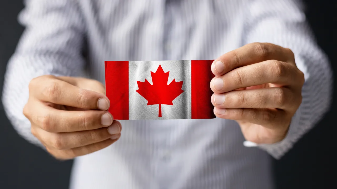 A business man holding a Canadian flag