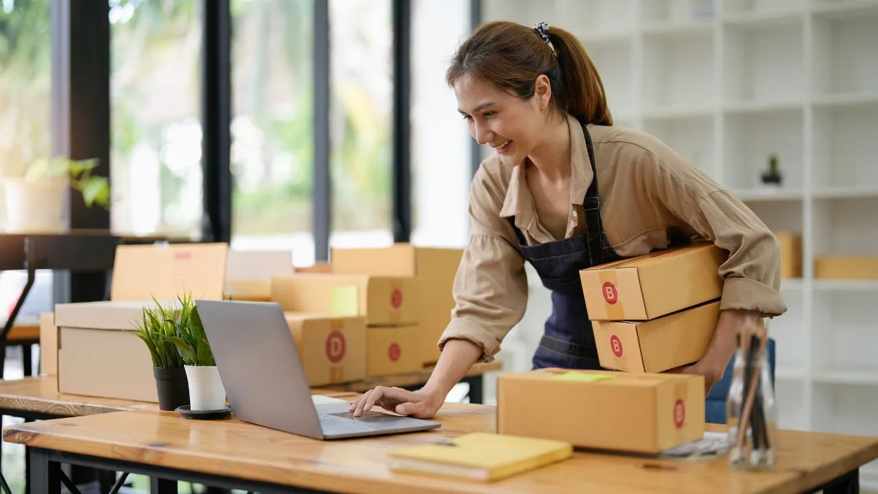 A seld-employed business owner packing boxes