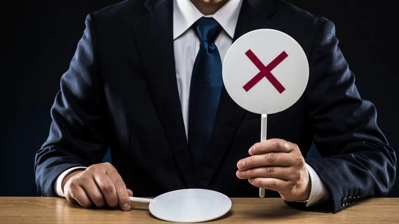 A business man holding up an X