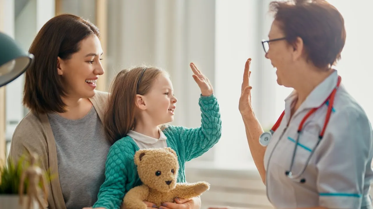 A healthcare worker giving a high five to a child