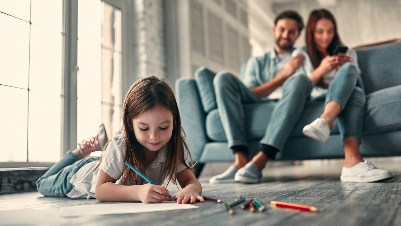 A happy family watching their daughter color