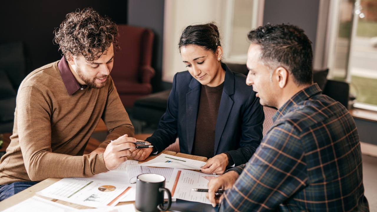 A group of people looking at paperwork around a table