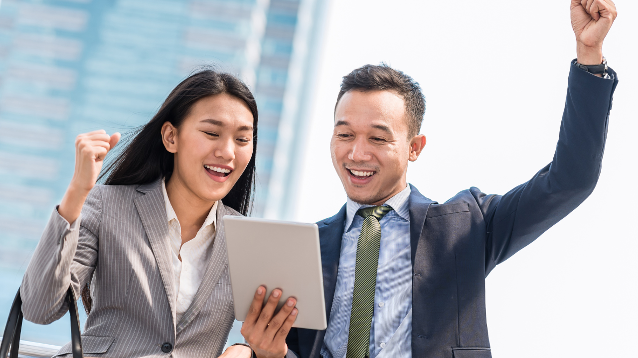 Two professionals reading an article on an Ipad