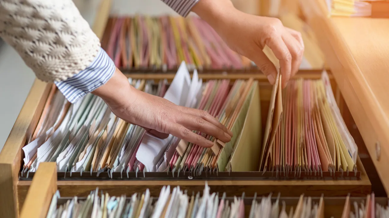 A woman going through a bunch of files in a filing cabinet