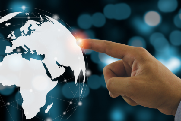A finger pointing to a location on the globe