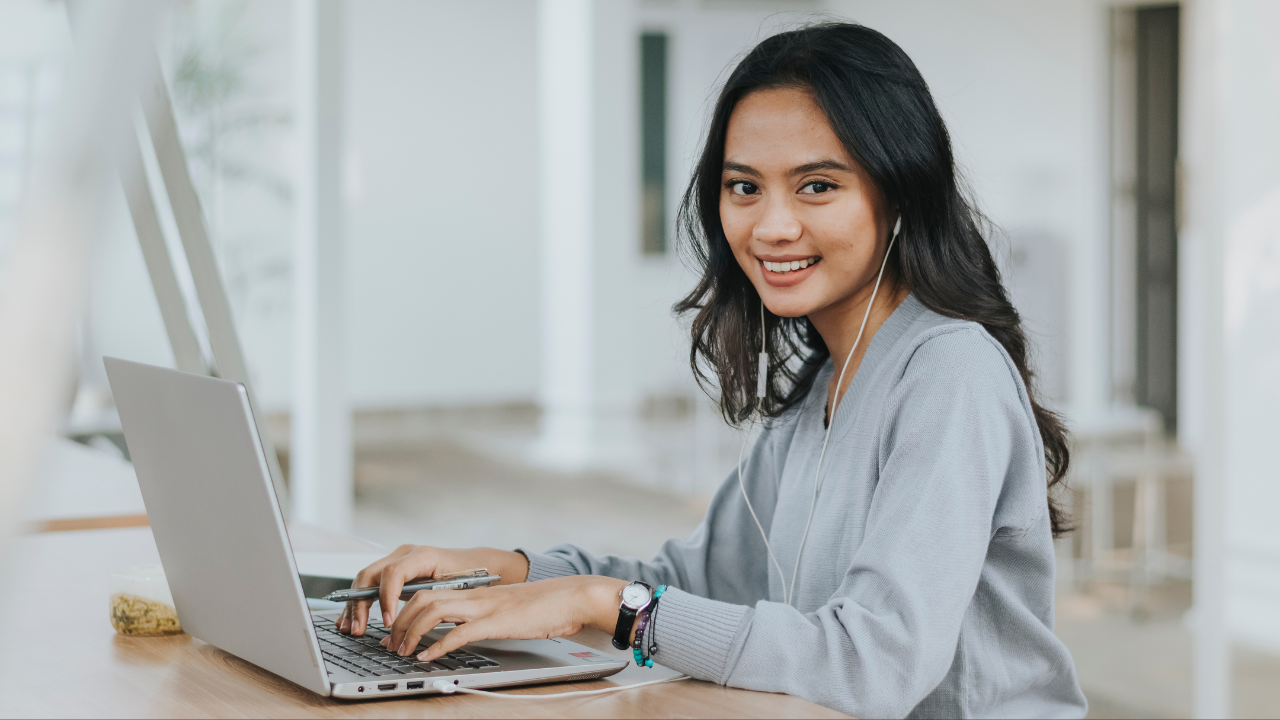 A woman working on her laptop while smiling