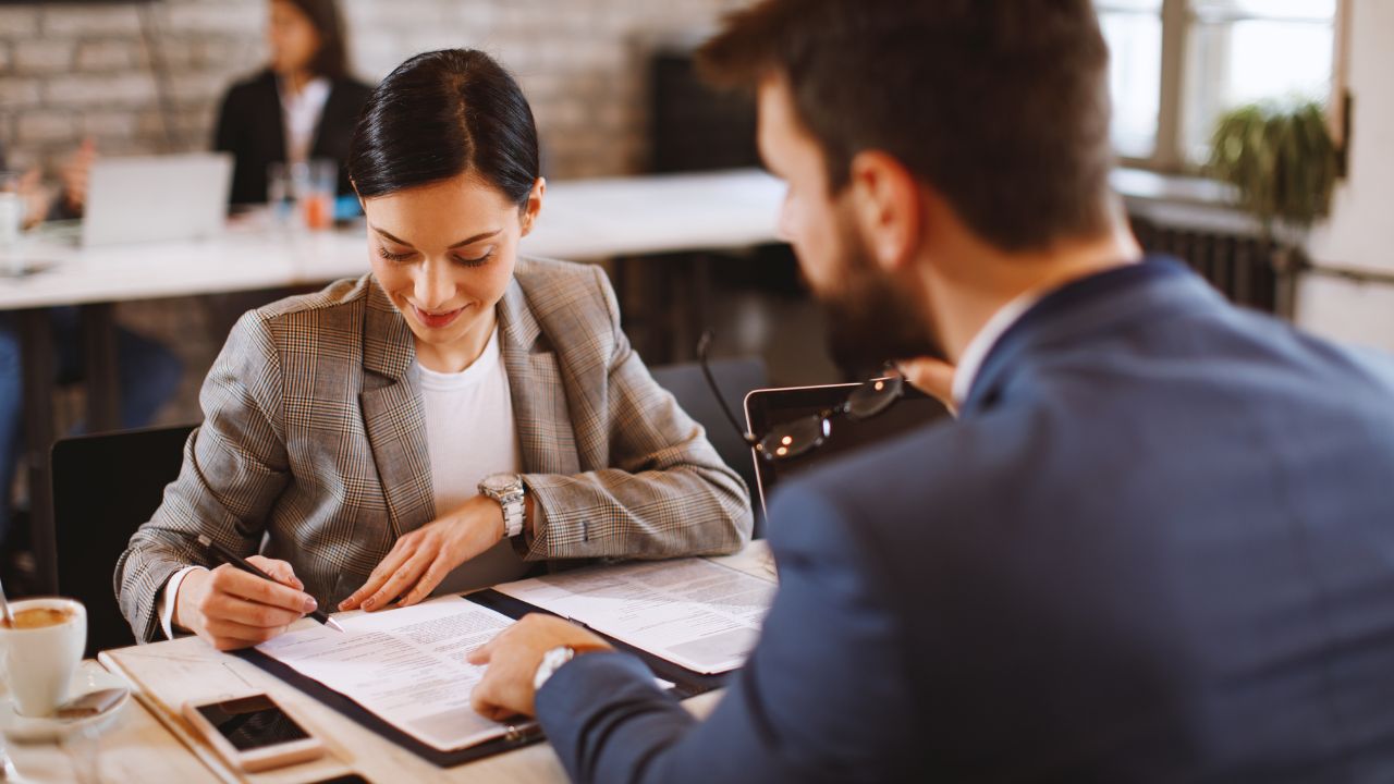 An employee and employer sitting at a desk together