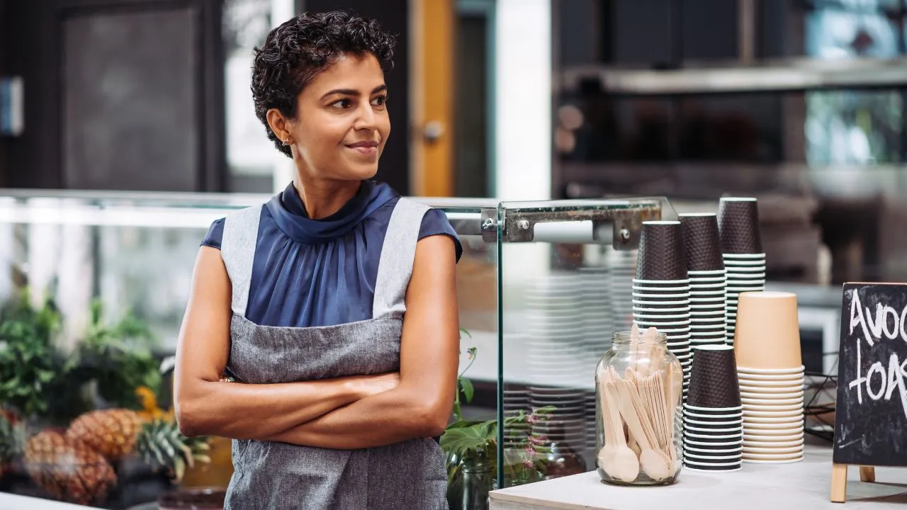 A self employed woman standing outside of her business