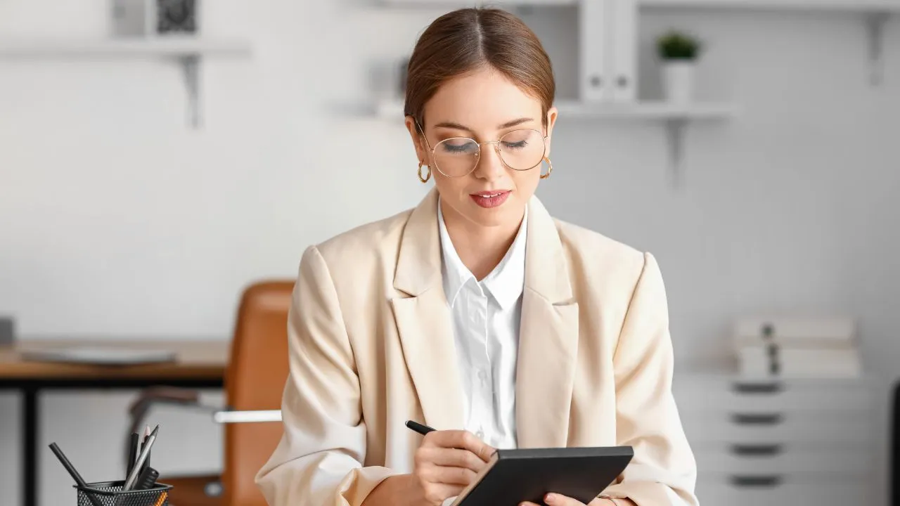 A woman taking notes in her home office