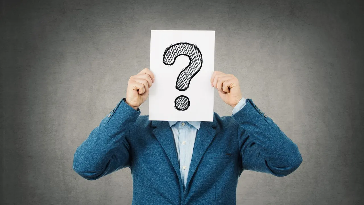 A man holding a question mark