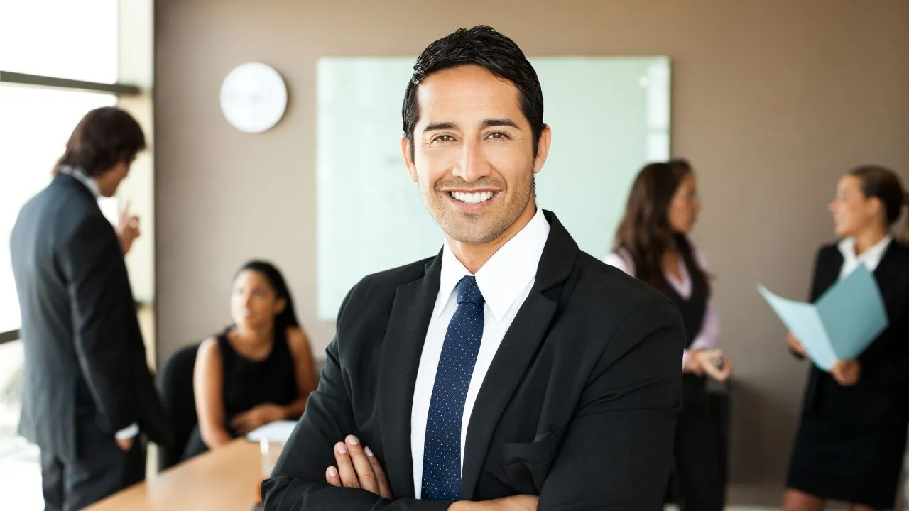 A manager standing in a board room with his team